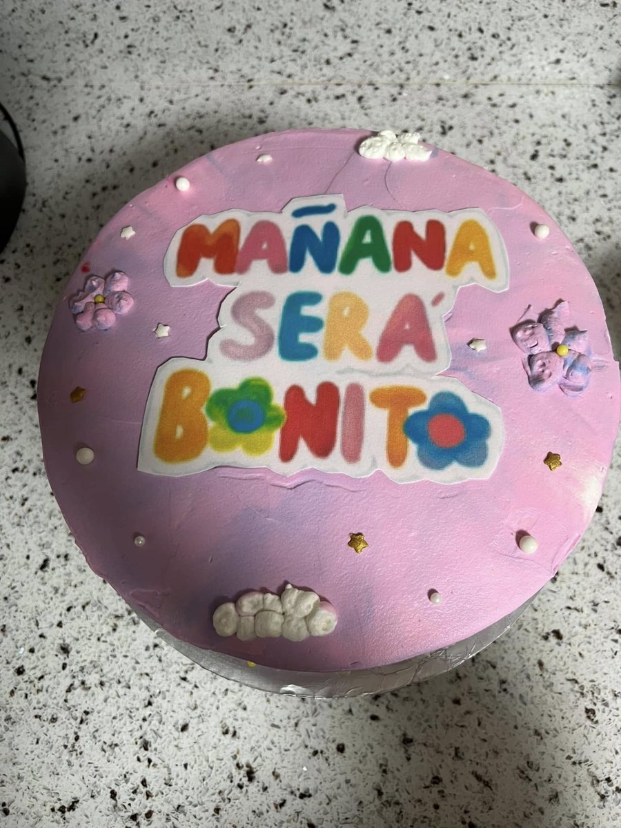Lavender cake decorated with the words Mañana Será Bonito and flowers